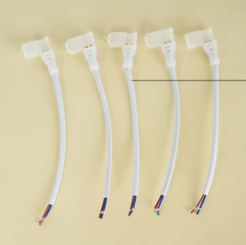 Five white connector wires with colorful ends arranged in a row on a beige background.