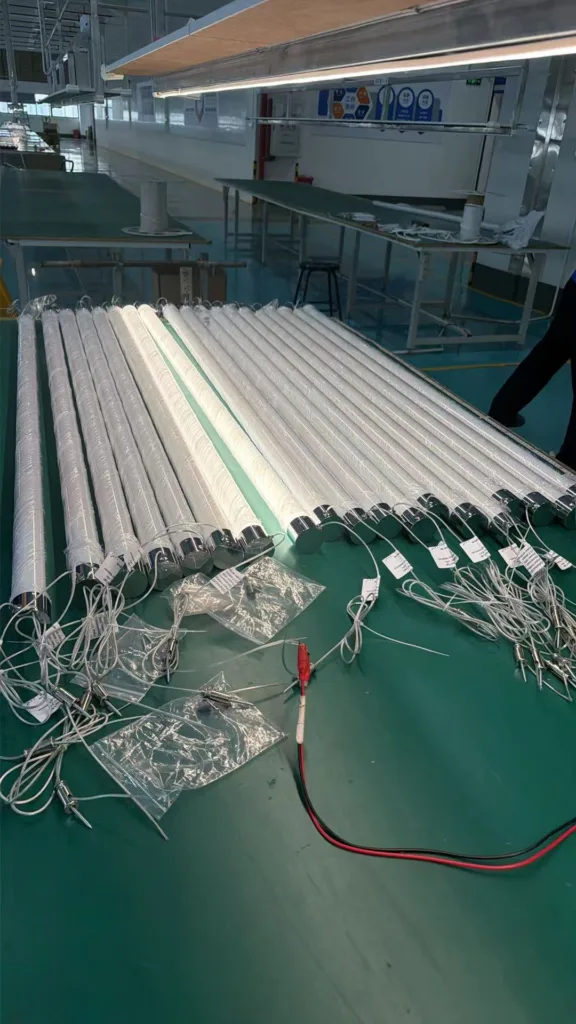 Rows of silicone neon flex tubes with wiring laid out on a factory table, positioned under well-lit conditions in a modern manufacturing environment.