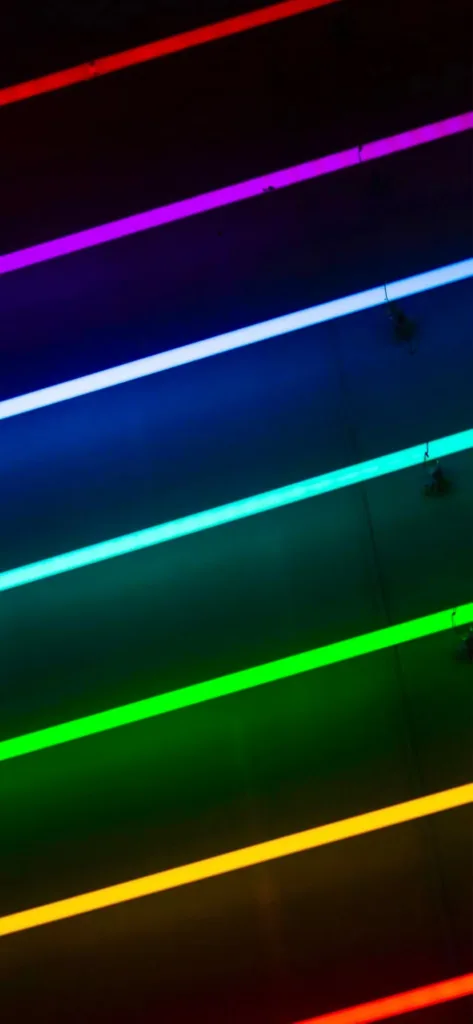 Vivid horizontal neon light strips in red, pink, blue, green, and yellow tones against a dark background.