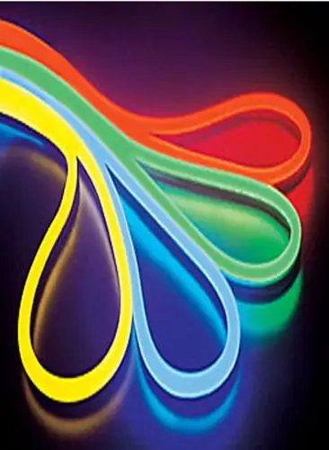 Close-up of flexible silicone neon flex lights in vibrant red, green, blue, and yellow colors forming loops on a dark background.