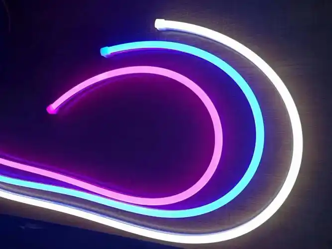 Curved silicone neon flex lighting in vibrant colors, including blue, pink, and white, displayed on a dark background.