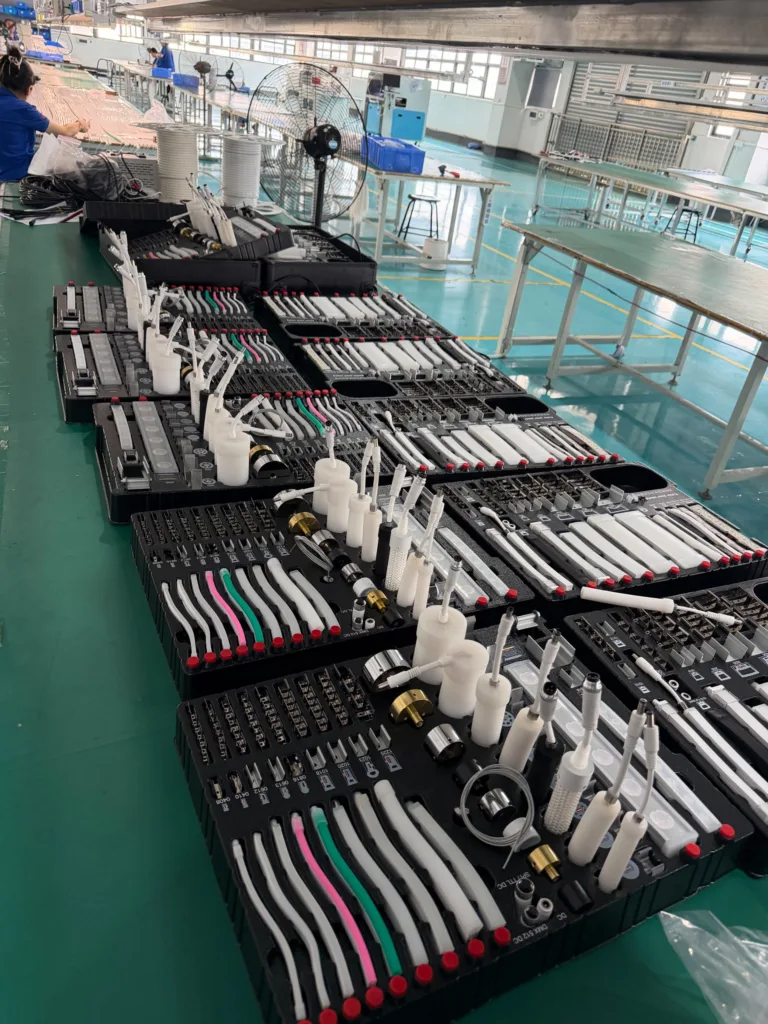 Multiple trays of silicone lighting components organized on a production line in a modern factory setting.